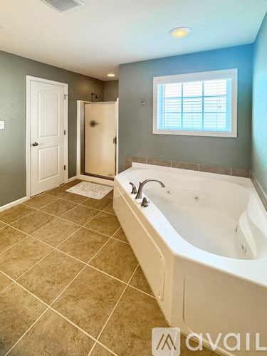 A bathroom with a large tub and a window.
