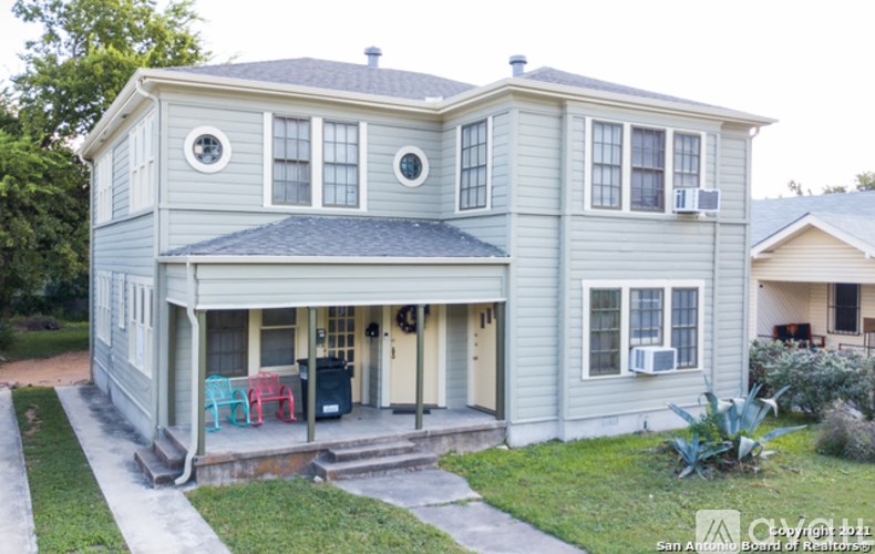 A two-story house with a front porch and a covered entrance.