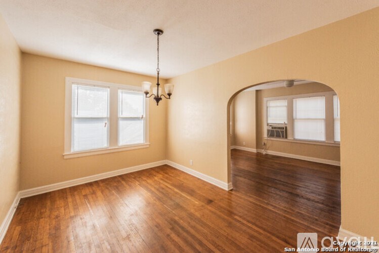 A room with wooden floors and a chandelier.