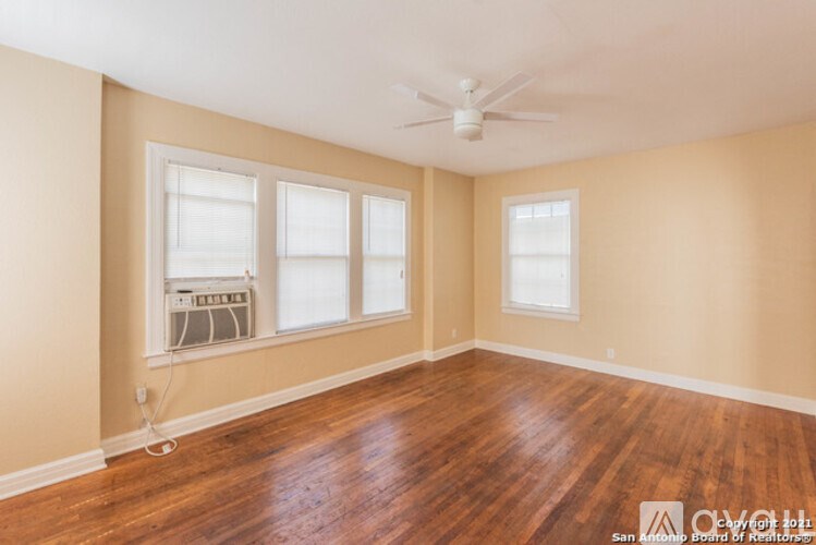 A room with wooden floors and a ceiling fan.