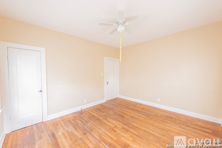 A room with wooden floors and a ceiling fan.