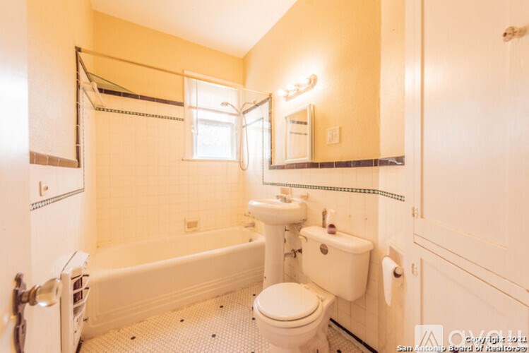 A small bathroom with a toilet, sink, and bathtub.