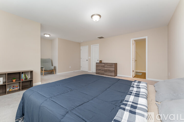 A bedroom with a bed covered in a blue comforter.