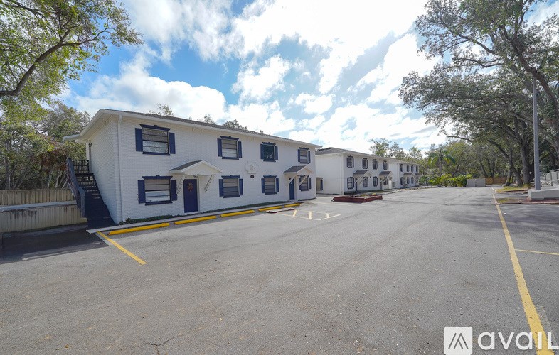 A parking lot with a white building and a yellow line.