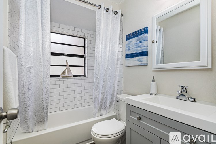 A bathroom with a white toilet, a white sink, and a white bathtub with a shower curtain.