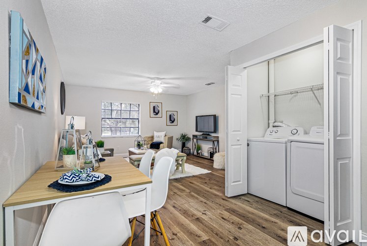 A kitchen with a dining table and chairs is shown.
