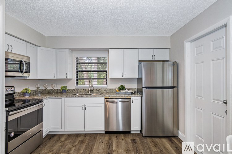 A kitchen with white cabinets and a stainless steel refrigerator.