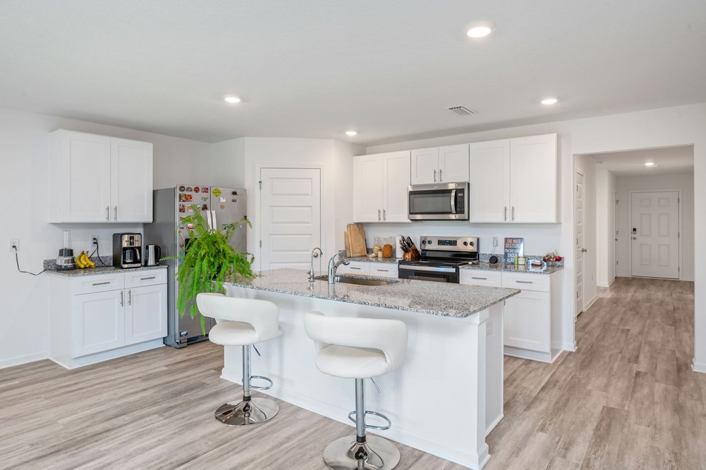 A modern kitchen with white cabinets and a central island.