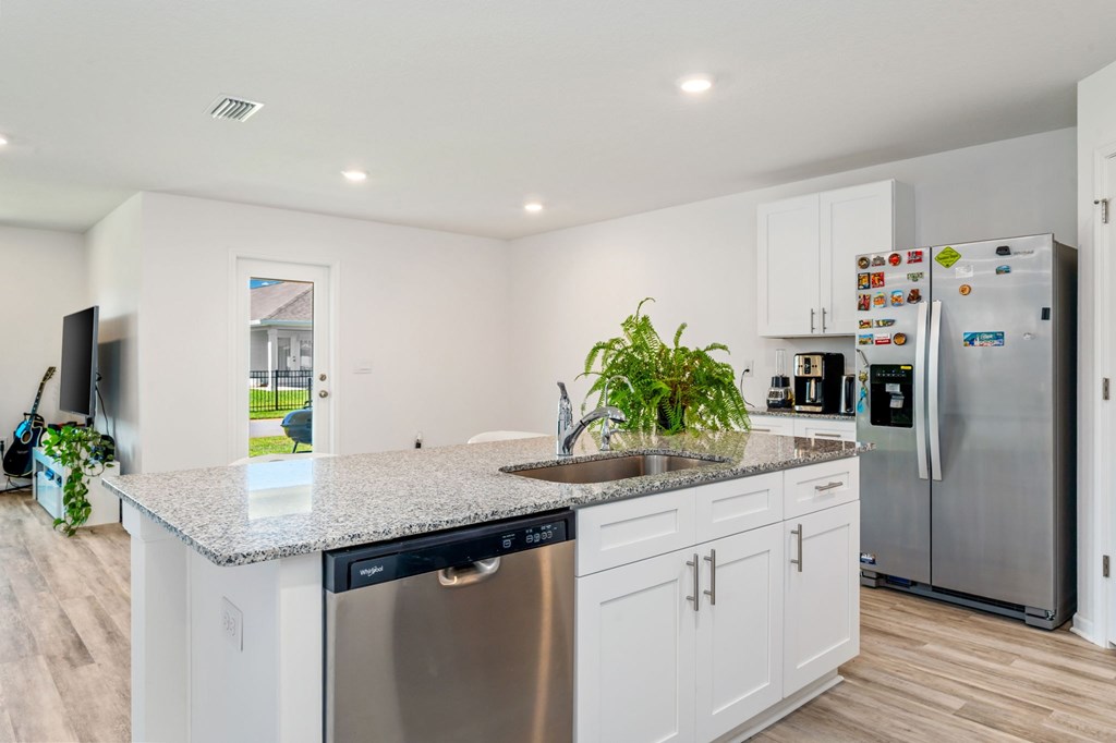A kitchen with white cabinets and a granite countertop.