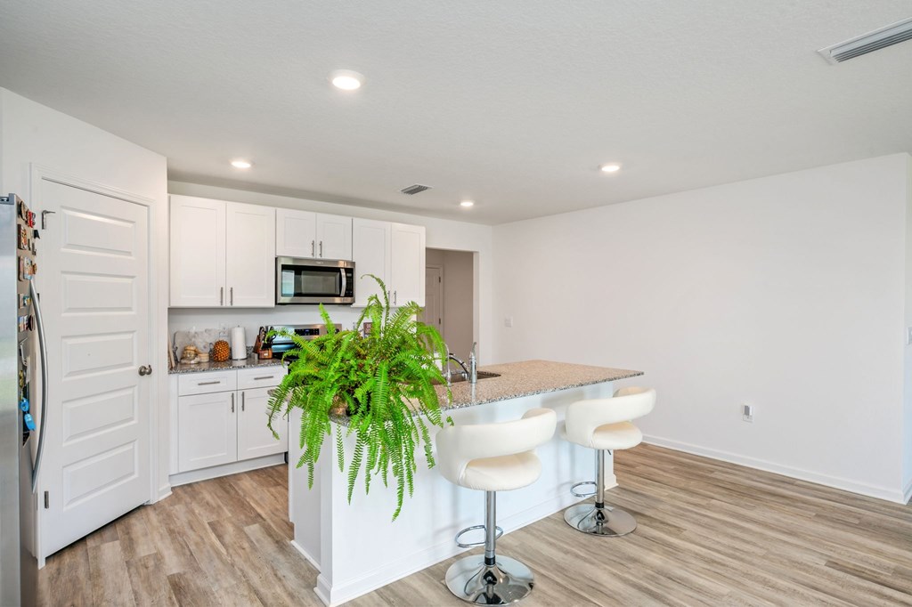 A kitchen with a bar and stools.
