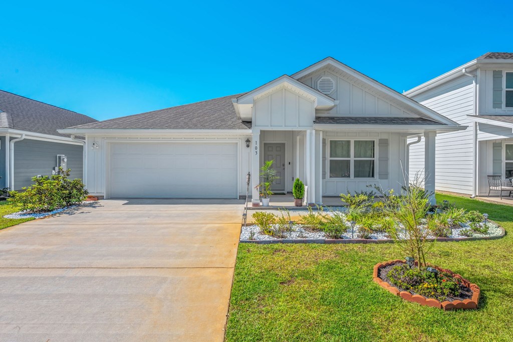 A house with a driveway and a landscaped front yard.