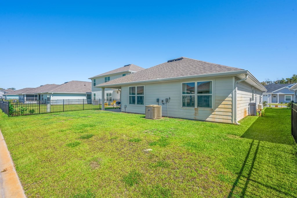 A house with a green lawn in front of it.
