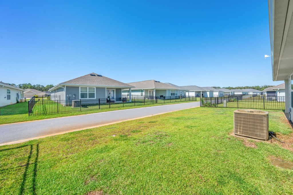 A sunny day at a residential area with houses and a green lawn.