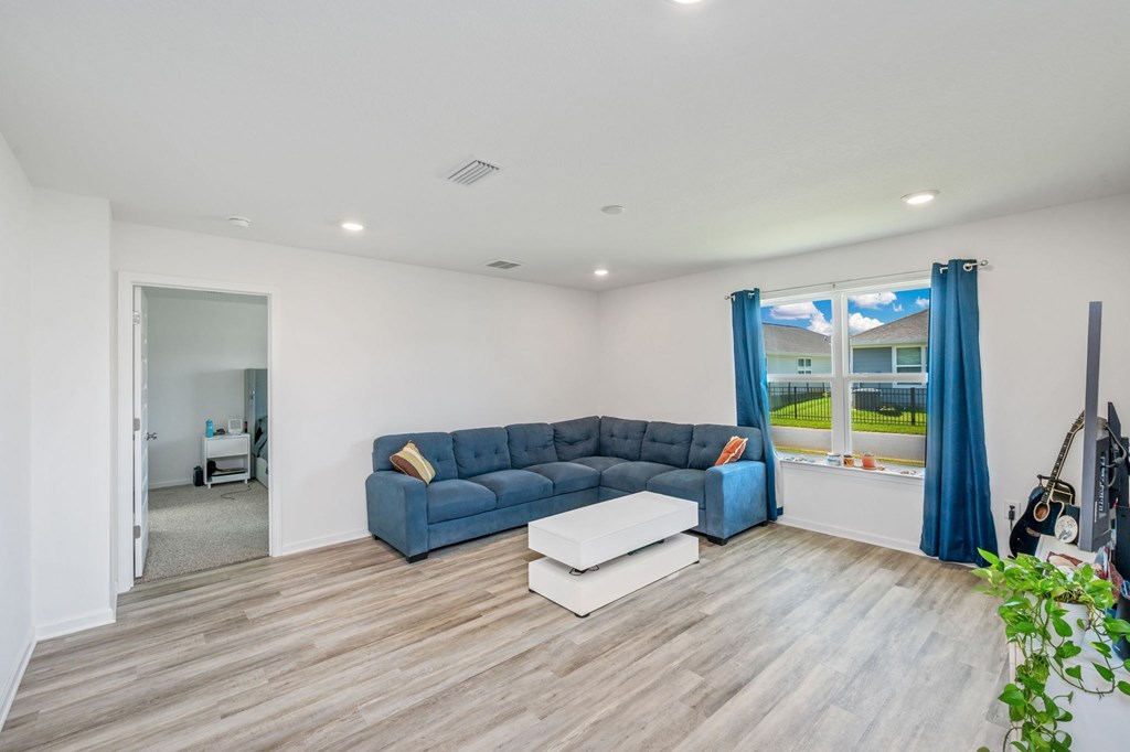 A living room with a blue couch and a white coffee table.