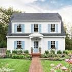 A white house with a grey roof and a blue door.