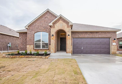A brick house with a garage door and a window.