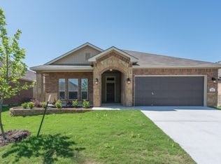A house with a brown garage door and a stone archway entrance.