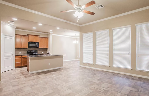 A kitchen with a countertop and a fan.