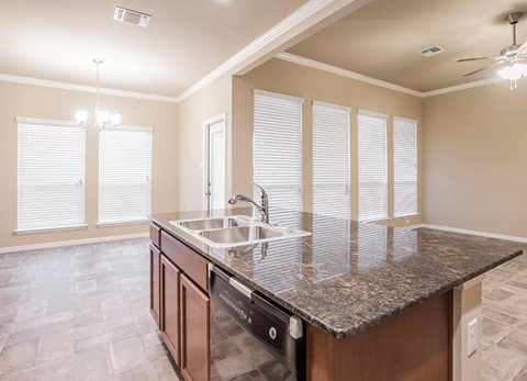 A kitchen with a granite countertop and a sink.