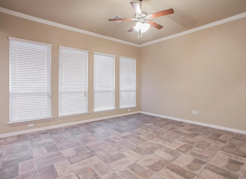 A room with a ceiling fan and tiled flooring.