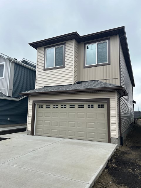 A two-story house with a garage door.