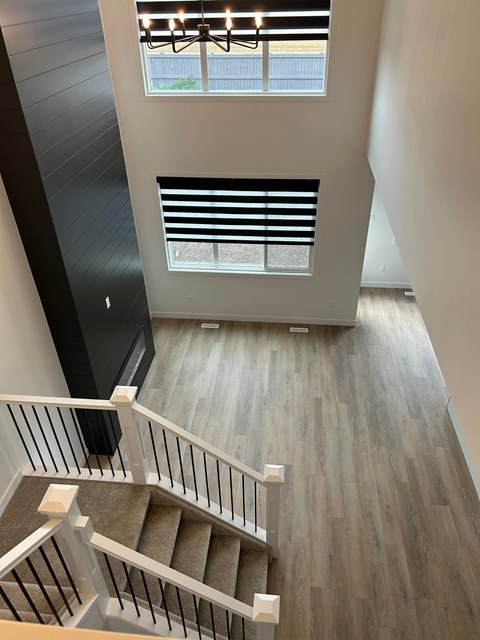 A staircase with a wooden floor and white railings.
