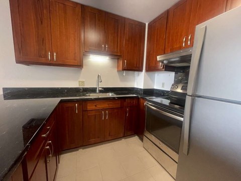 A kitchen with wooden cabinets and a black countertop.