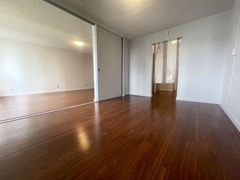 A room with wooden flooring and a sliding door.