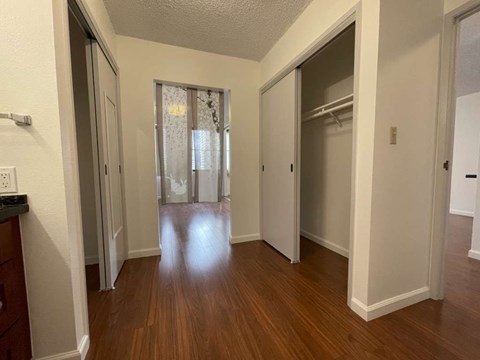 A hallway with wood floors and white walls.