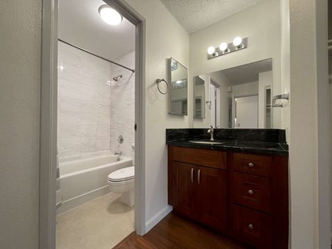 A bathroom with a toilet, sink, and mirror.