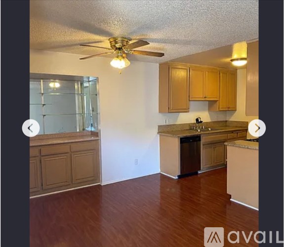 A kitchen with wooden cabinets and a ceiling fan.