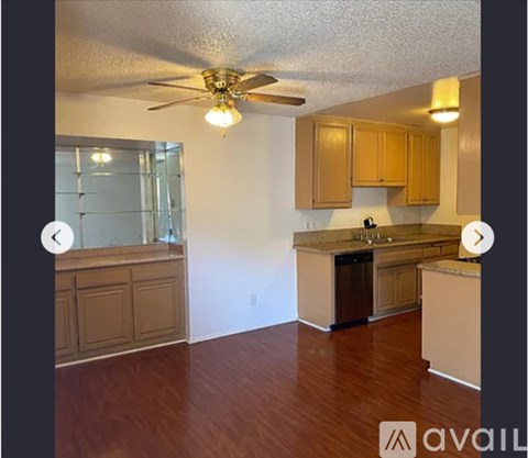 A kitchen with wooden cabinets and a ceiling fan.