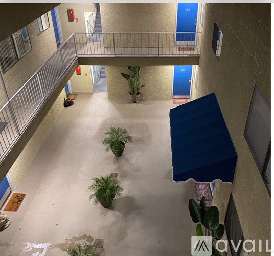 A balcony with a blue awning and potted plants.