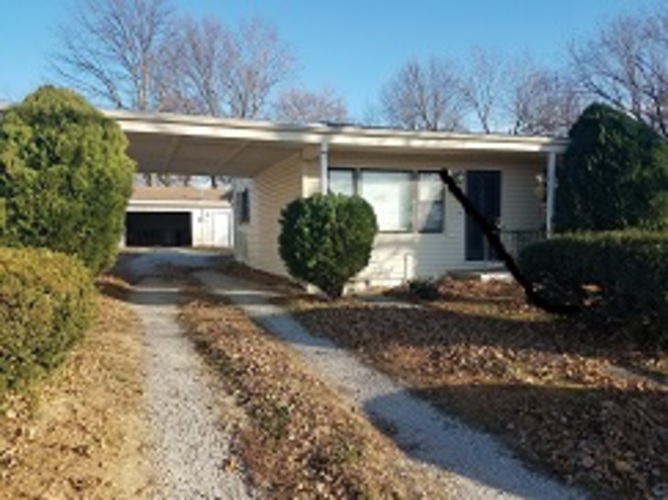A house with a gravel driveway in front.