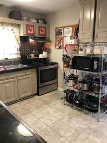 A kitchen with a black counter top and a black oven.