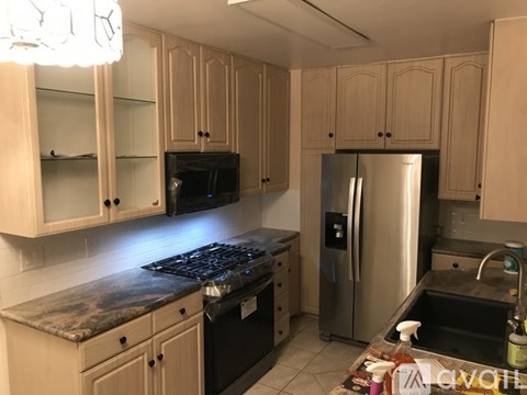 A kitchen with wooden cabinets and a black stove top.