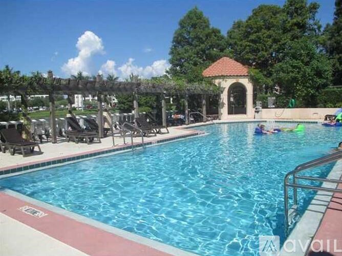 A pool with people swimming and sunbathing.