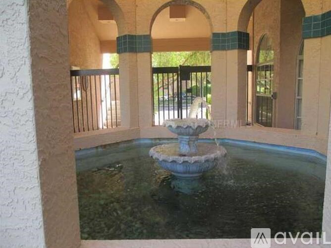 A fountain in the middle of a courtyard surrounded by arches.