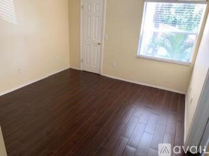 A room with wooden flooring and a window.
