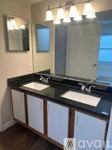 A bathroom with two sinks and a mirror.