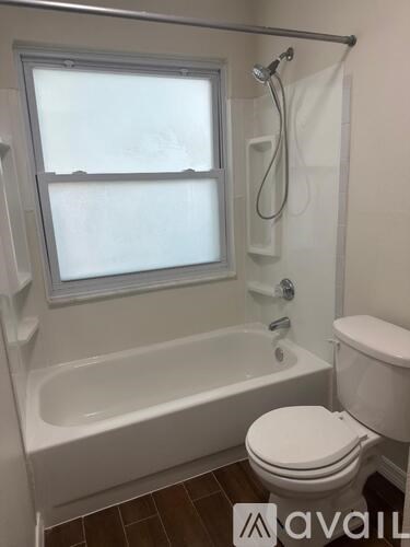 A white toilet sits next to a bathtub in a bathroom.