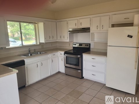 A kitchen with white cabinets and appliances.