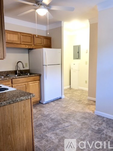 A kitchen with a granite countertop and wooden cabinets.
