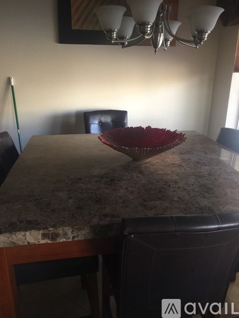 A bowl of red chopsticks sits on a marble table.