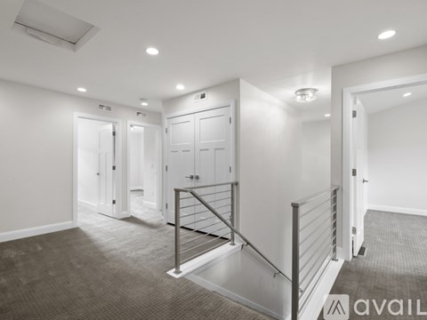 A spacious room with a staircase and a carpeted floor.