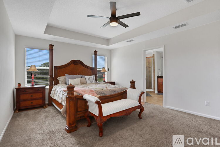 A bedroom with a large bed and a ceiling fan.