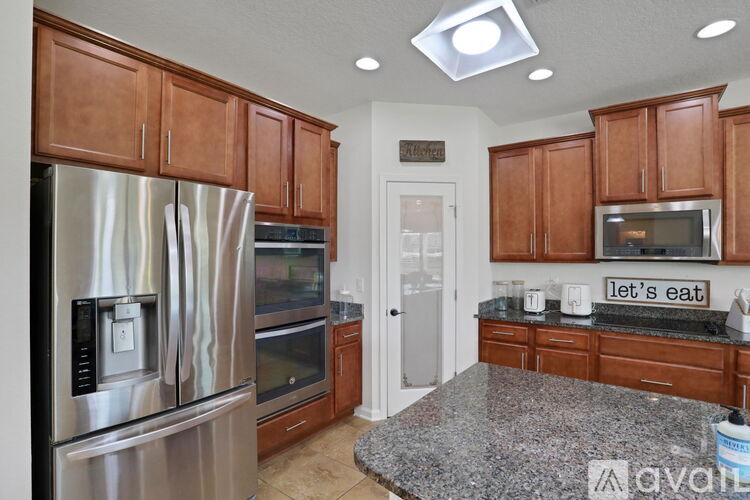 A kitchen with wooden cabinets and granite countertops.