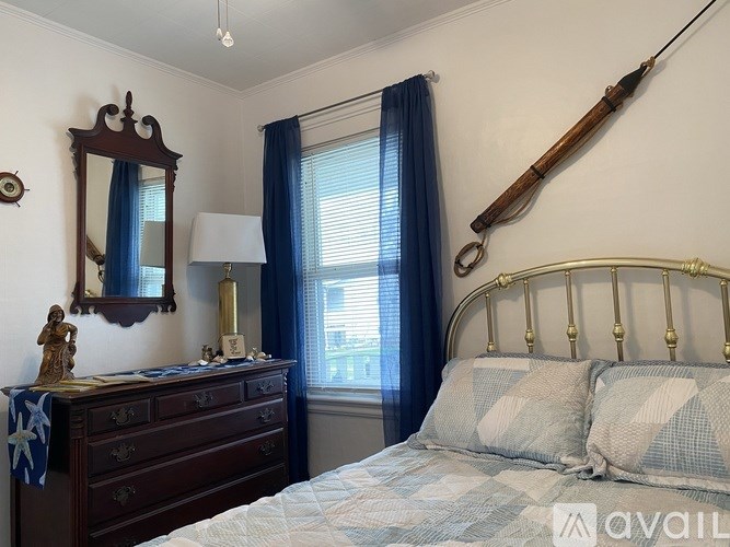 A bedroom with a bed, dresser, and a mirror.