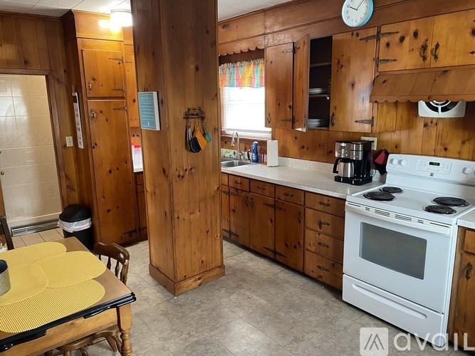 A kitchen with wooden cabinets and a white stove top oven.
