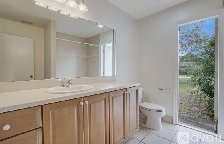 A bathroom with a sink, toilet, and mirror.